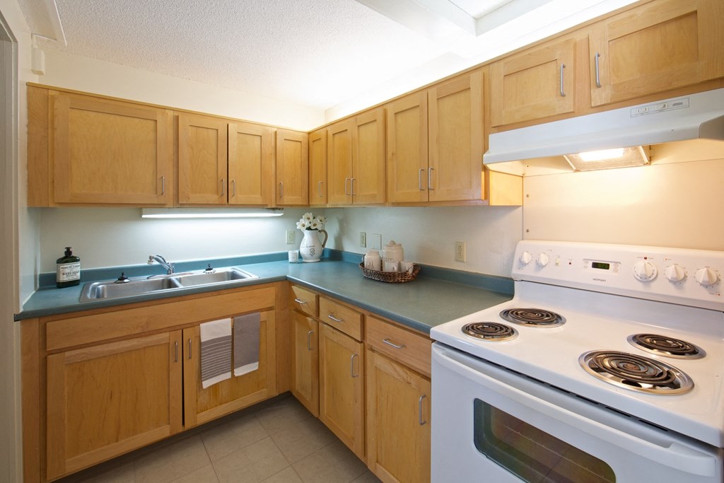 a kitchen with white appliances and wooden cabinets