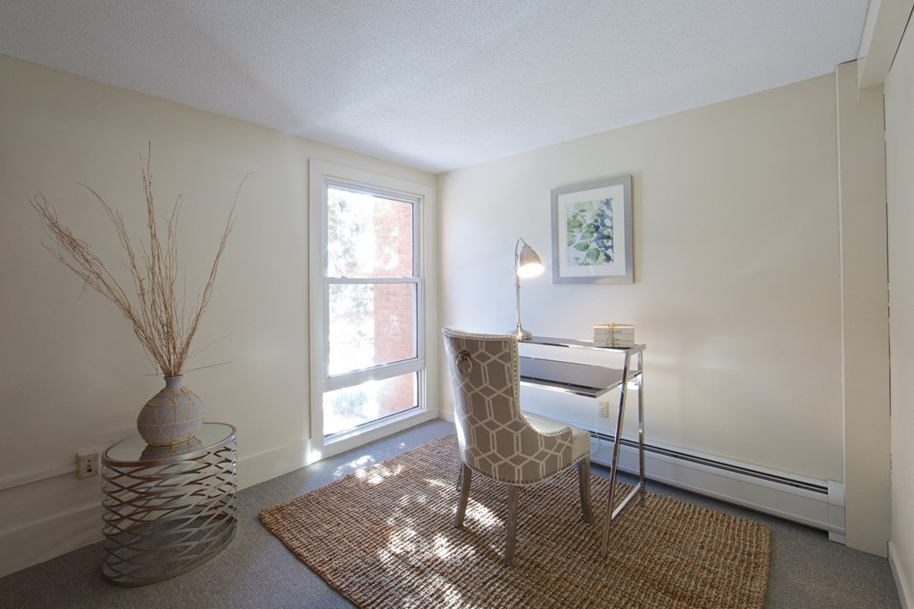 a room with a desk and a chair and a window