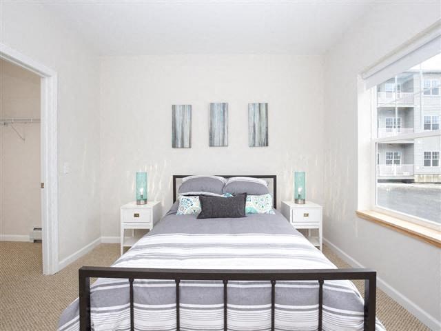 a bedroom with a bed and two windows