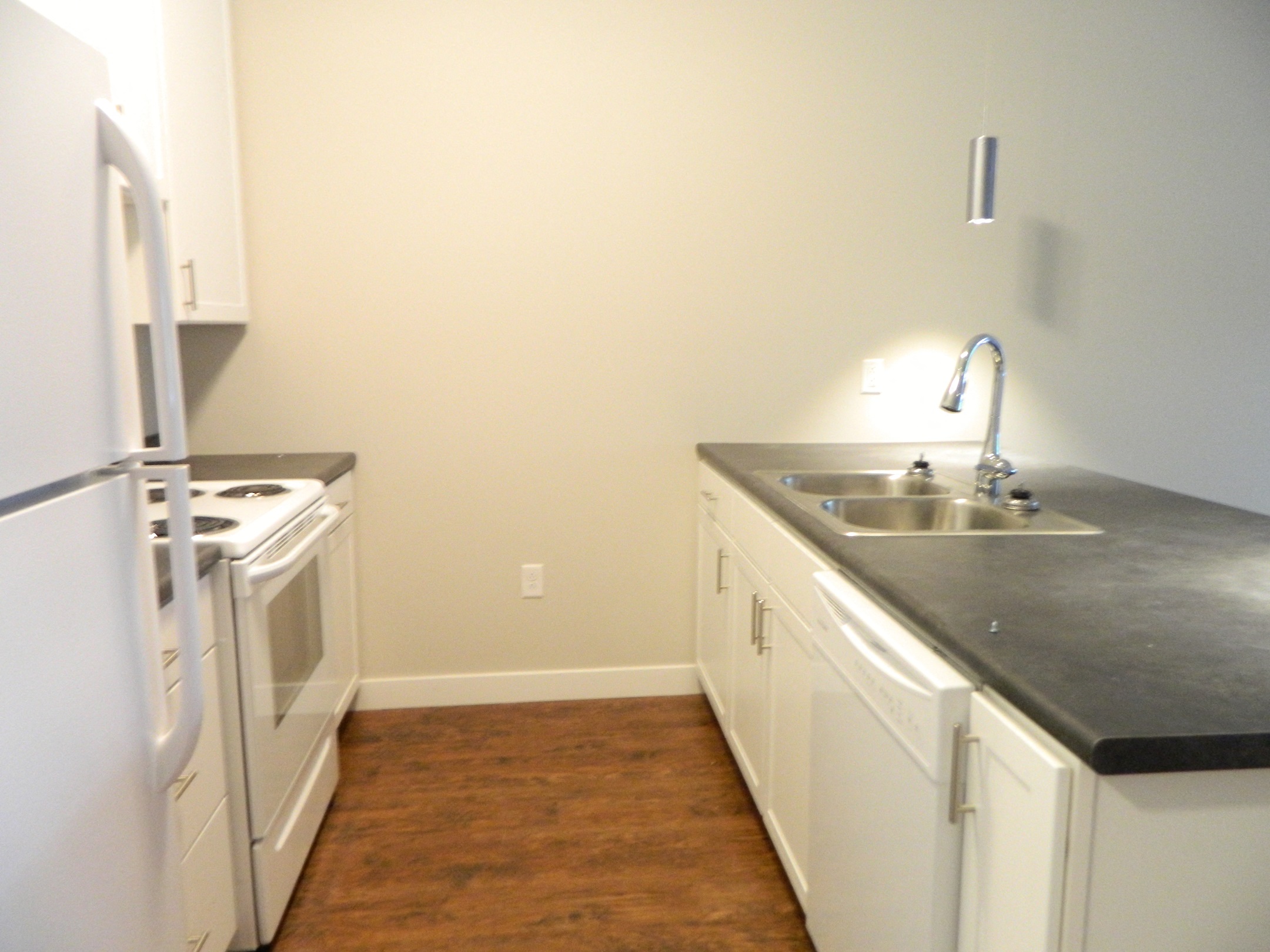 a kitchen with white cabinets and a sink and a refrigerator