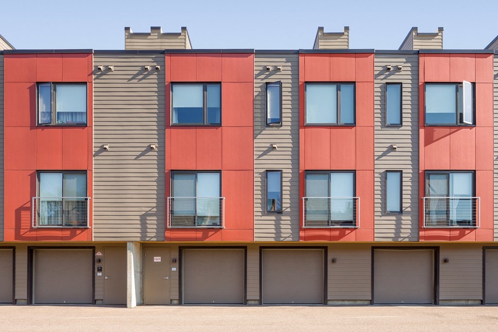 the exterior of a building with red and gray facade and windows