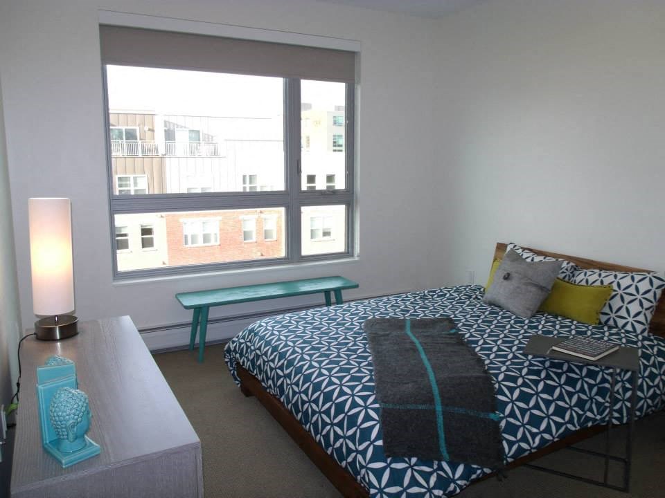 a bedroom with a bed and a table and a window