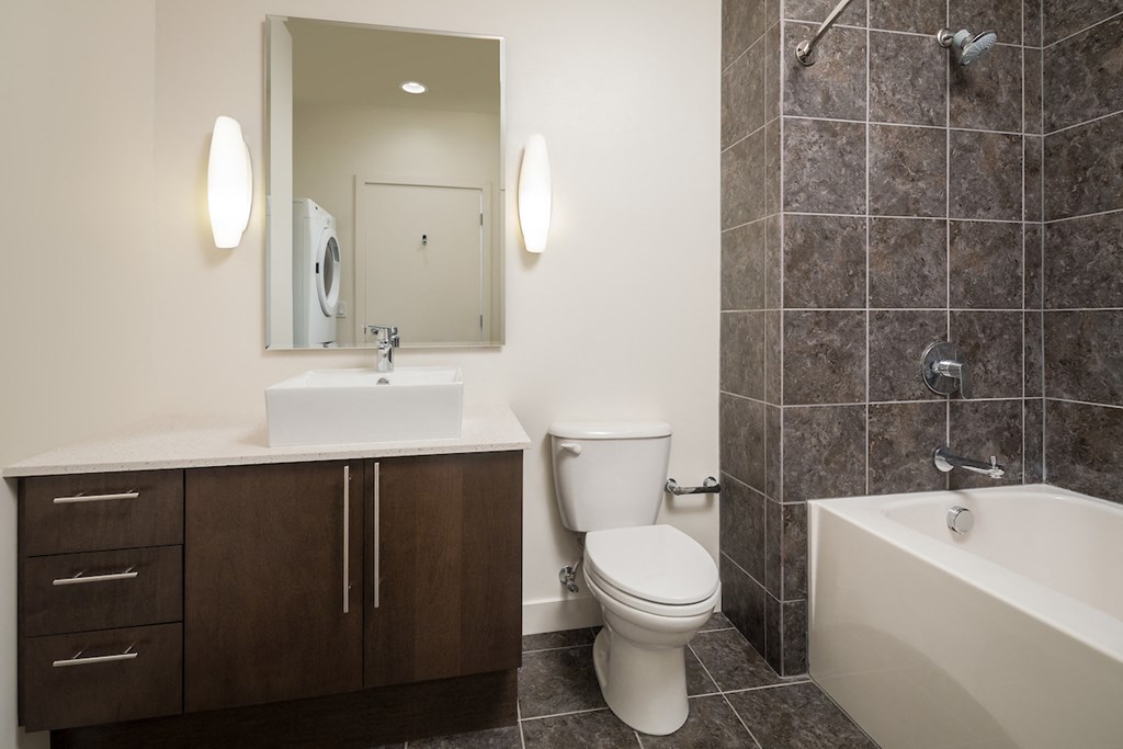 a bathroom with a toilet sink and tub and a mirror