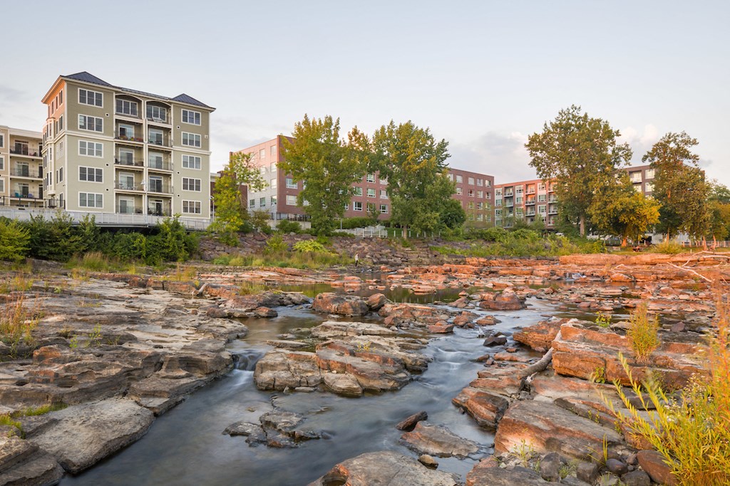 a creek with rocks in front of a building