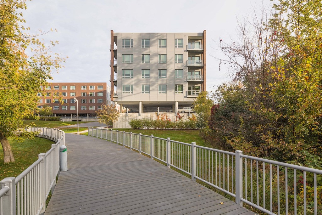 a bridge over a park with a building in the background