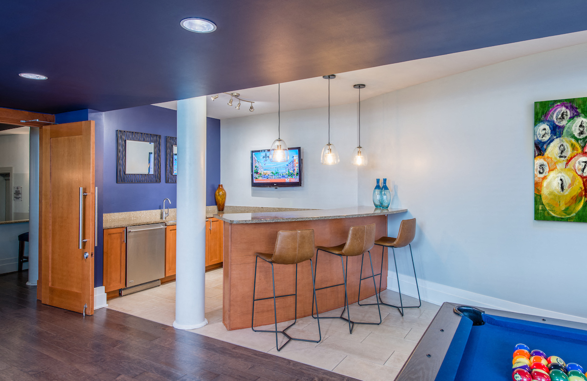 a living room with a bar and a pool