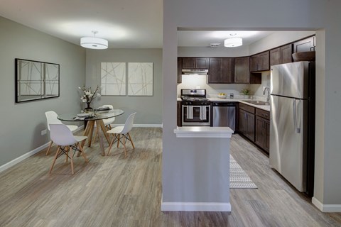 a kitchen and dining room with stainless steel appliances and a table
