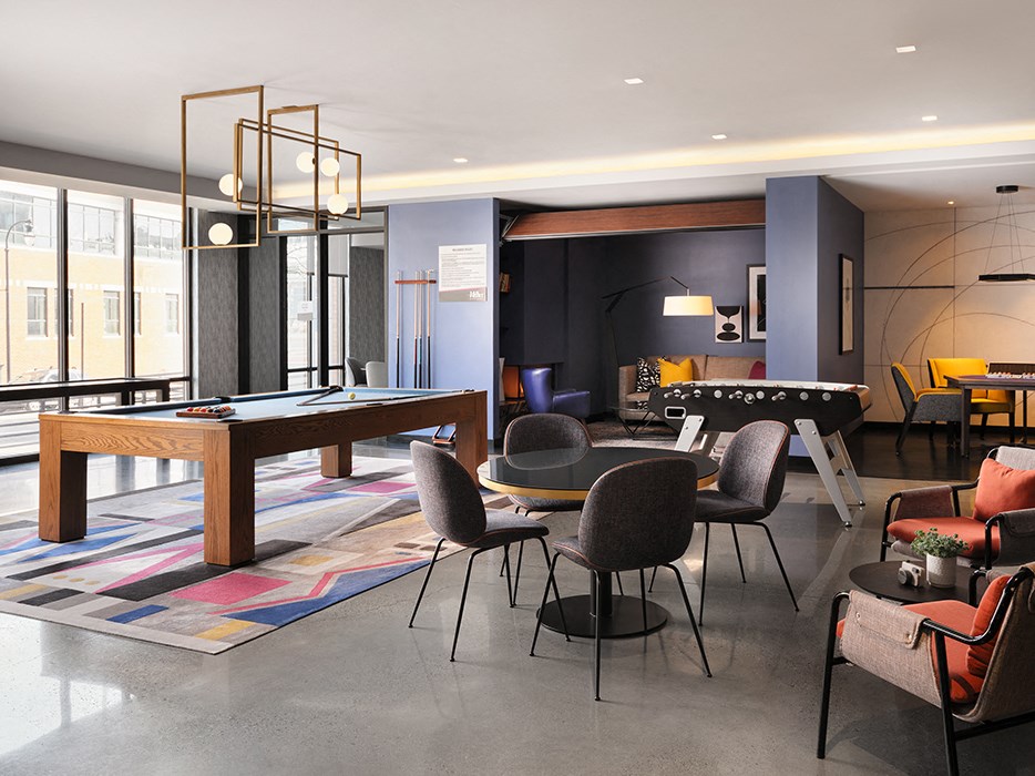 a living room with a pool table and a dining table and chairs
