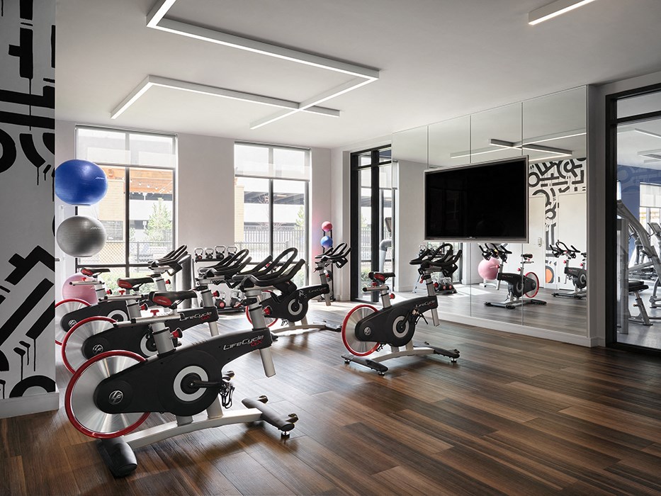 a gym with a variety of exercise bikes and a tv