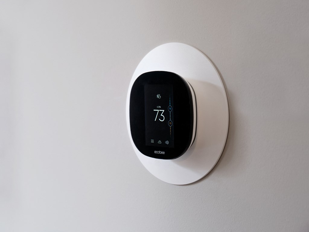 a digital thermostat on a white wall