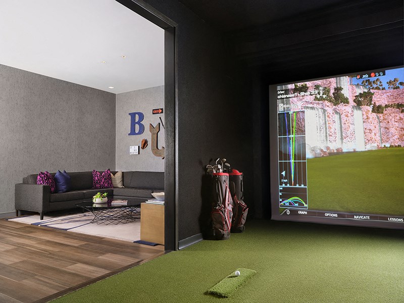 a living room with a large screen tv and a golf game