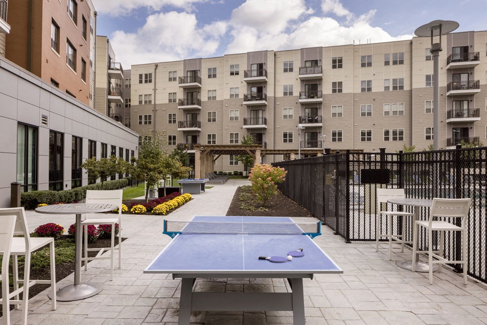 a ping pong table in a courtyard with an apartment building