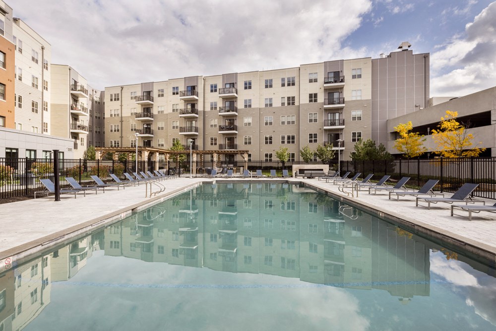 a swimming pool with an apartment building in the background