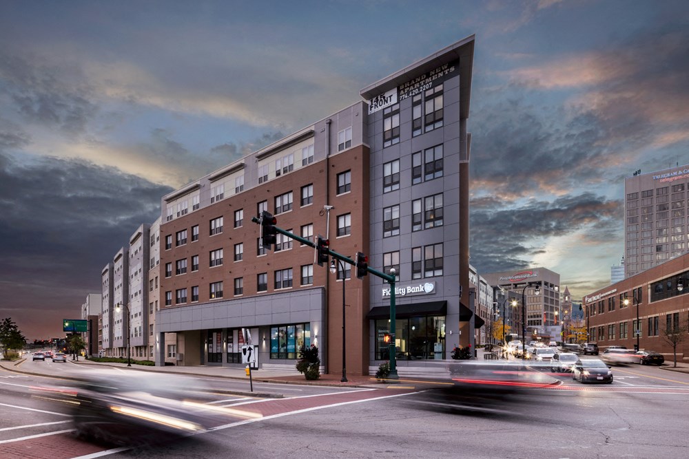 a large building on a city street with cars driving by