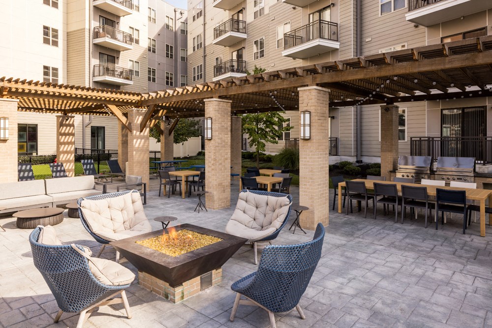 a patio with tables and chairs and a fire pit