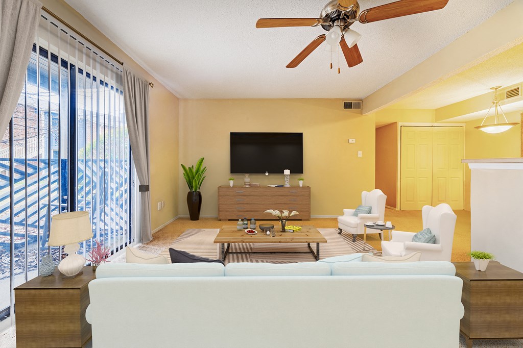 a living room with a large window and a ceiling fan