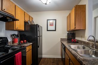 full kitchen with black appliances and granite counter tops and wooden cabinets