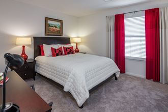 a bedroom with a white bed and red curtains