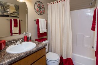 a bathroom with a sink toilet and shower and a shower curtain