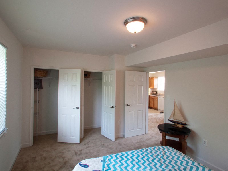 a bedroom with a bed and two closets and a door to a bathroom