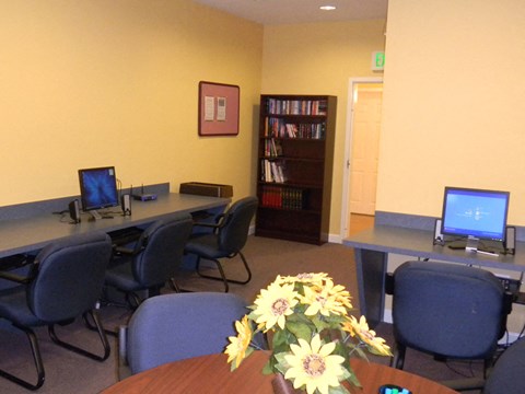 a conference room with computers and a table with flowers