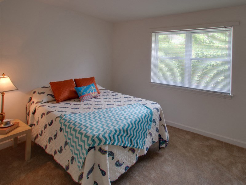 a bedroom with a bed and two windows