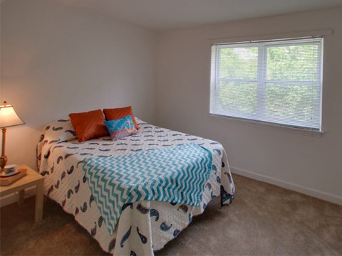 a bedroom with a bed and two windows