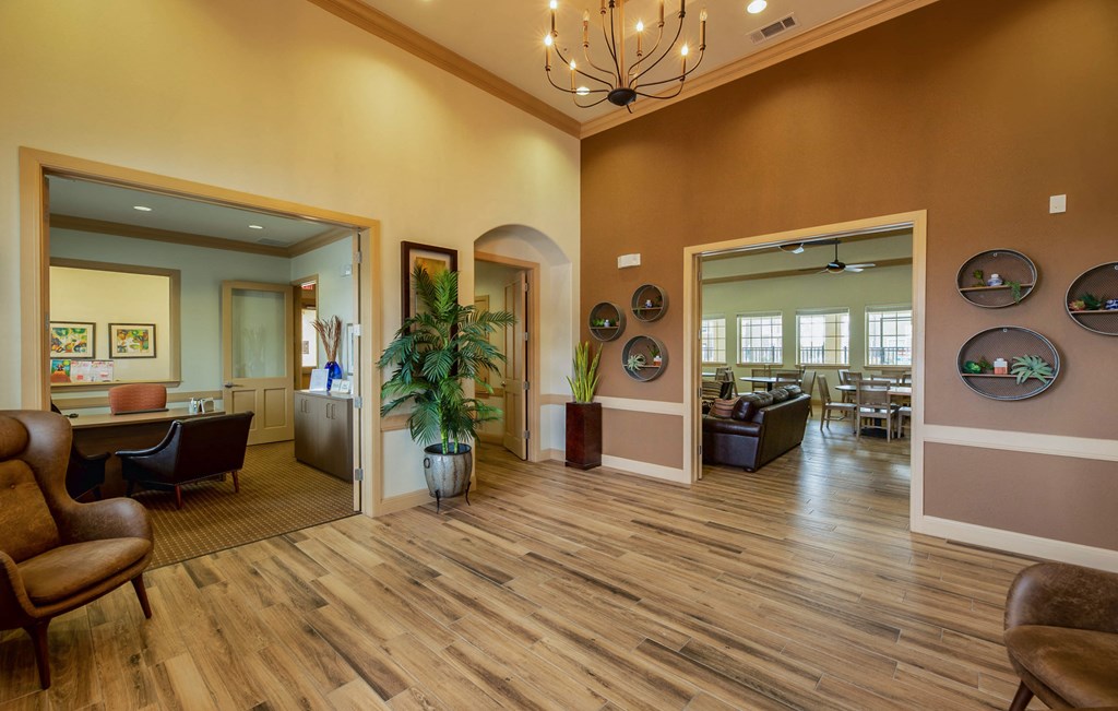 a lobby with a wooden floor and chairs and a table