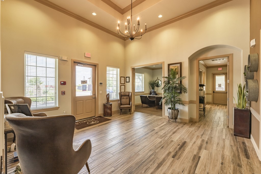 a living room with chairs and a chandelier