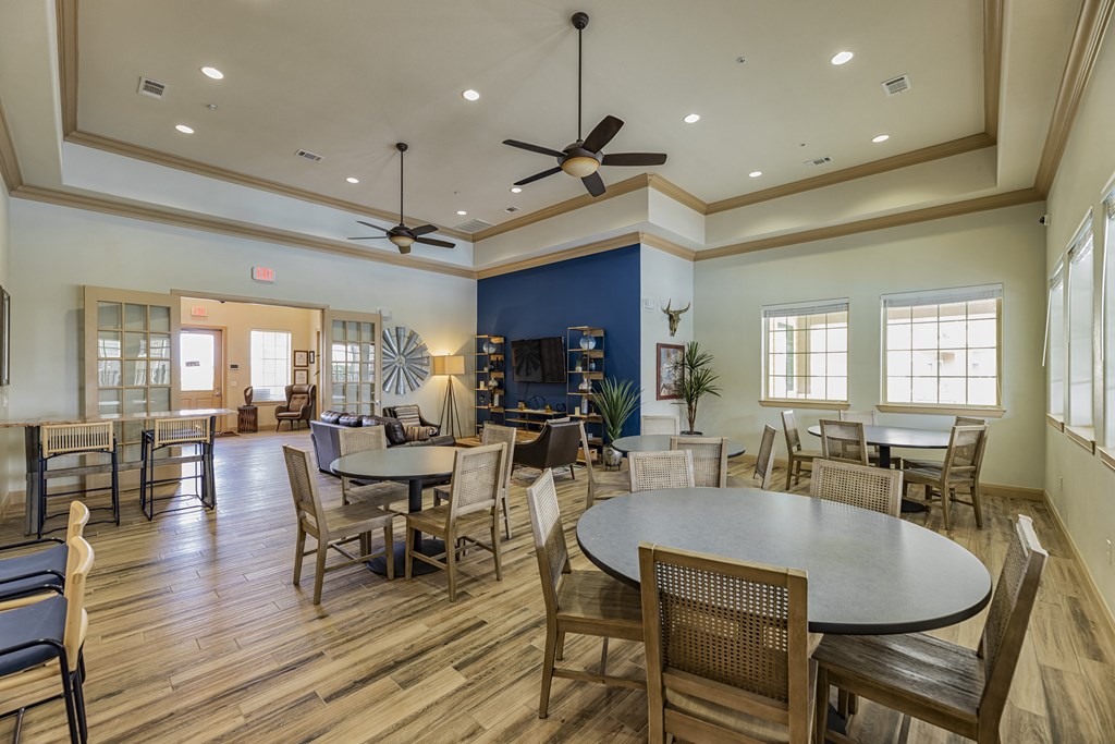 a large living room with tables and chairs and a television