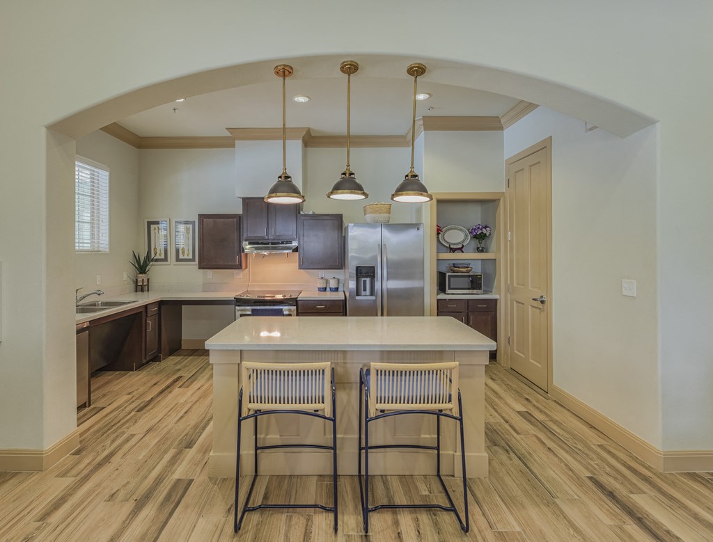 an open kitchen with a large island with three stools
