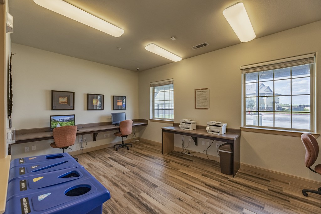 a common room with desks and chairs and a blue pool table