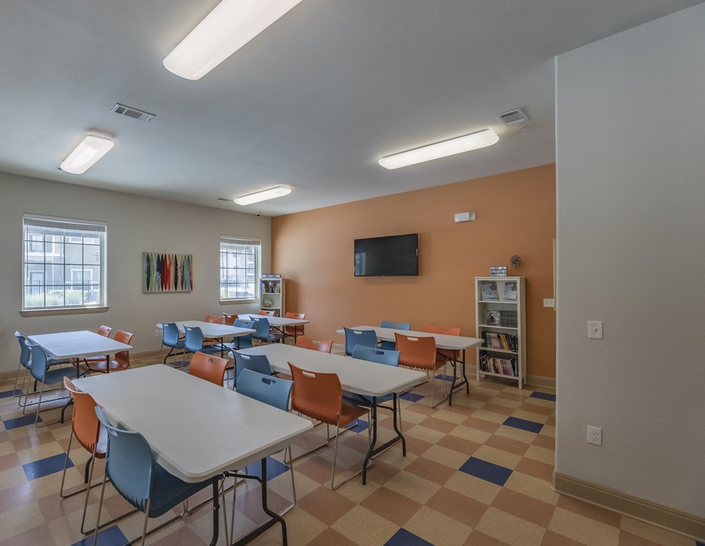 a dining room with tables and chairs and a tv