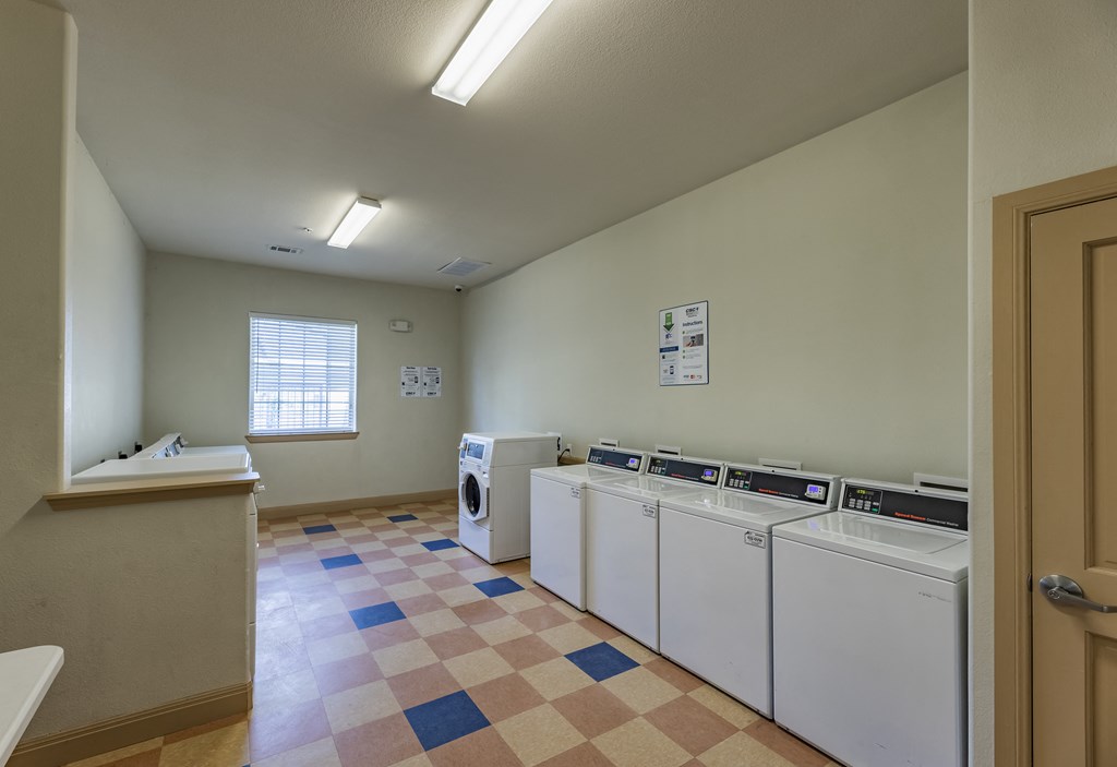 a laundry room with washers and dryers and a window