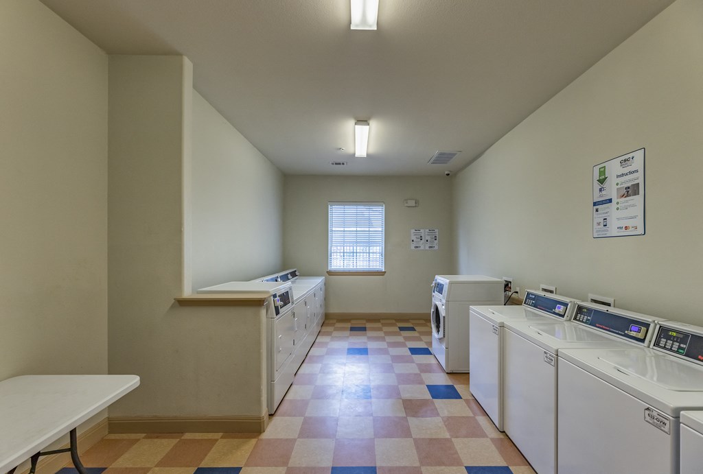 a laundry room with washes and dryers and a window