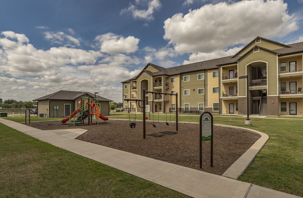 an empty playground in front of an apartment building