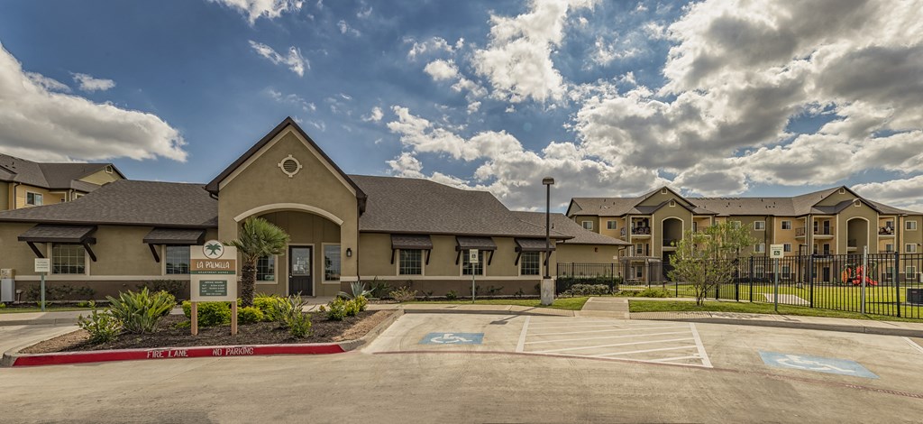 an empty parking lot in front of an apartment building