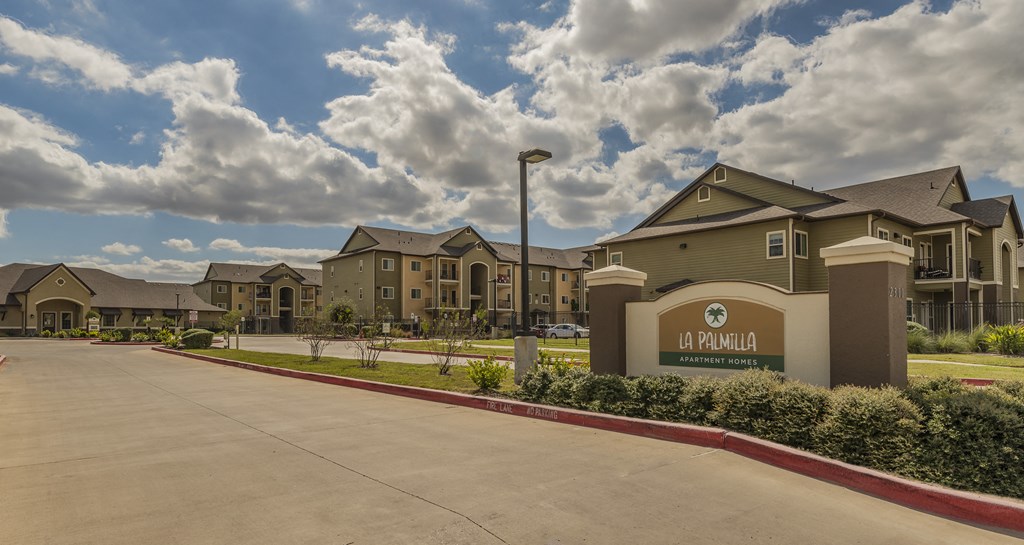 an empty parking lot in front of an apartment building