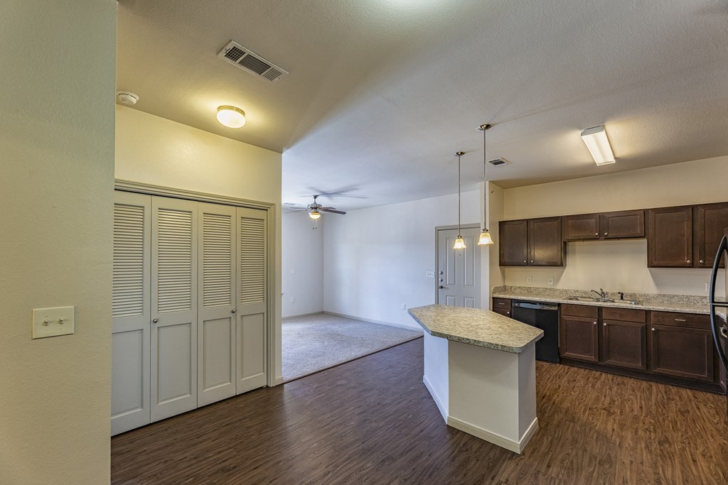an empty kitchen and living room with a counter top in the middle