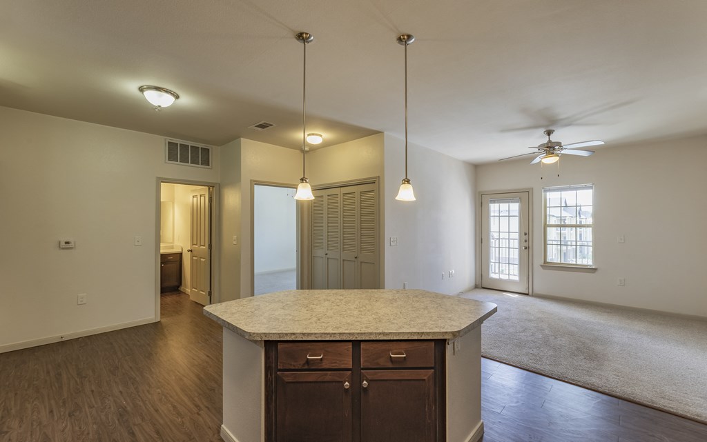an empty kitchen and living room with a ceiling fan