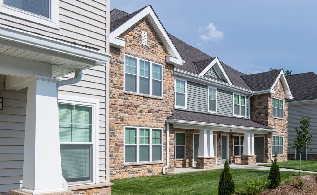 a view of the front of a house with stone and gray siding