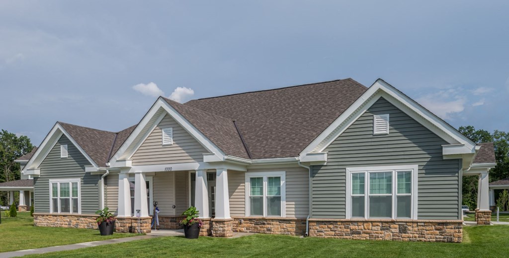 a blue house with a brown roof and a yard