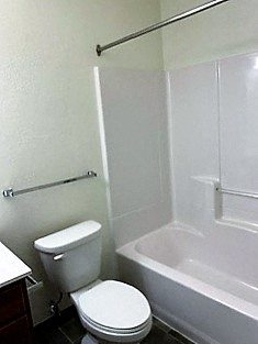 a white bathroom with a toilet and a tub