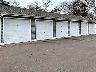 a row of white garage doors on the side of a building