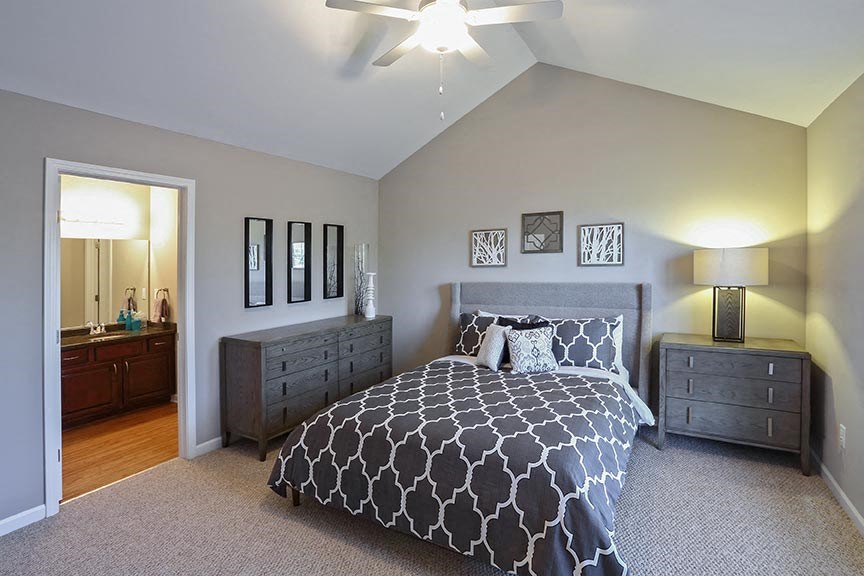 a bedroom with a bed and a ceiling fan