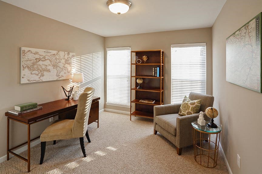 a living room with a desk and a chair