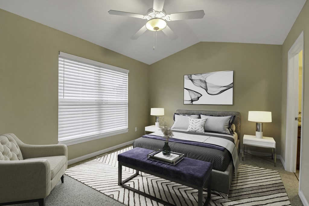 a bedroom with a large window and a ceiling fan