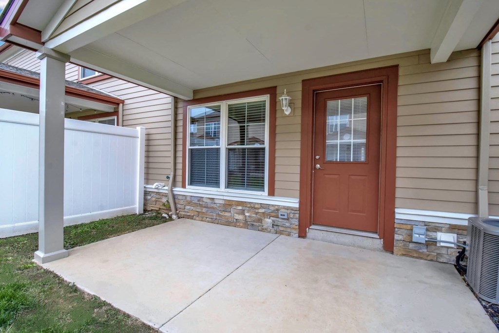 the front porch of a home with a red door