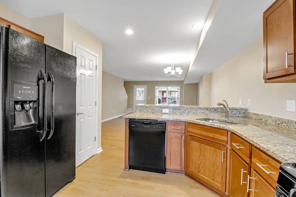 a kitchen with a black refrigerator and a sink