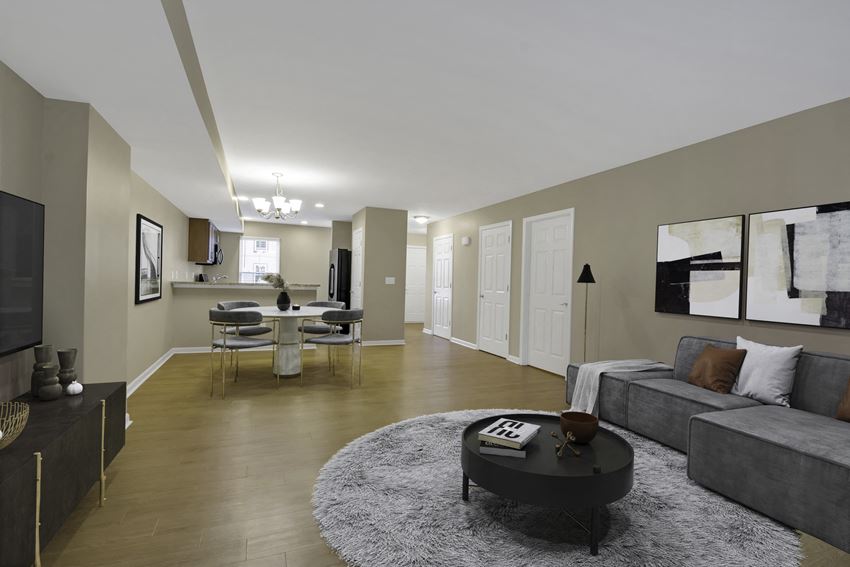 a living room with a couch and a coffee table in front of a dining room